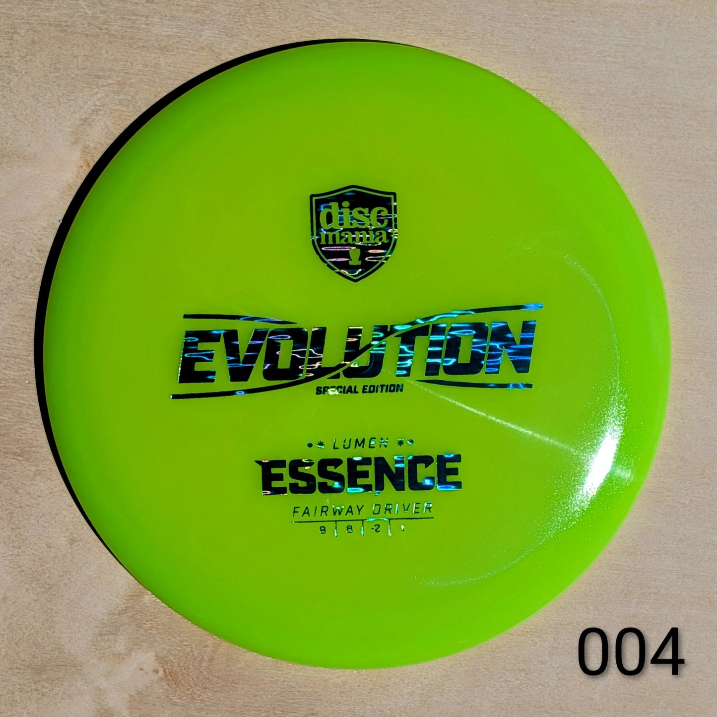 Green disc golf disc with 'Discmania' logo and text on a beige background