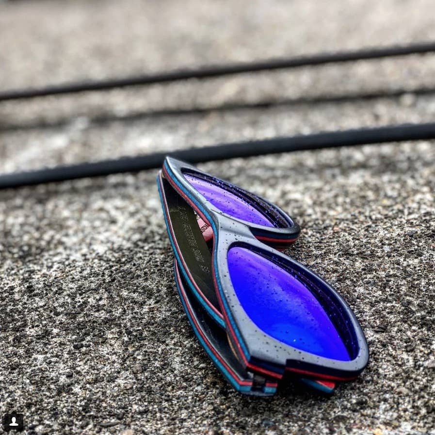 ollie black Blue and black sunglasses on a concrete surface