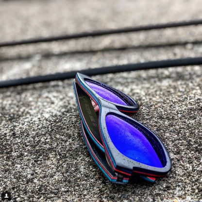 ollie black Blue and black sunglasses on a concrete surface
