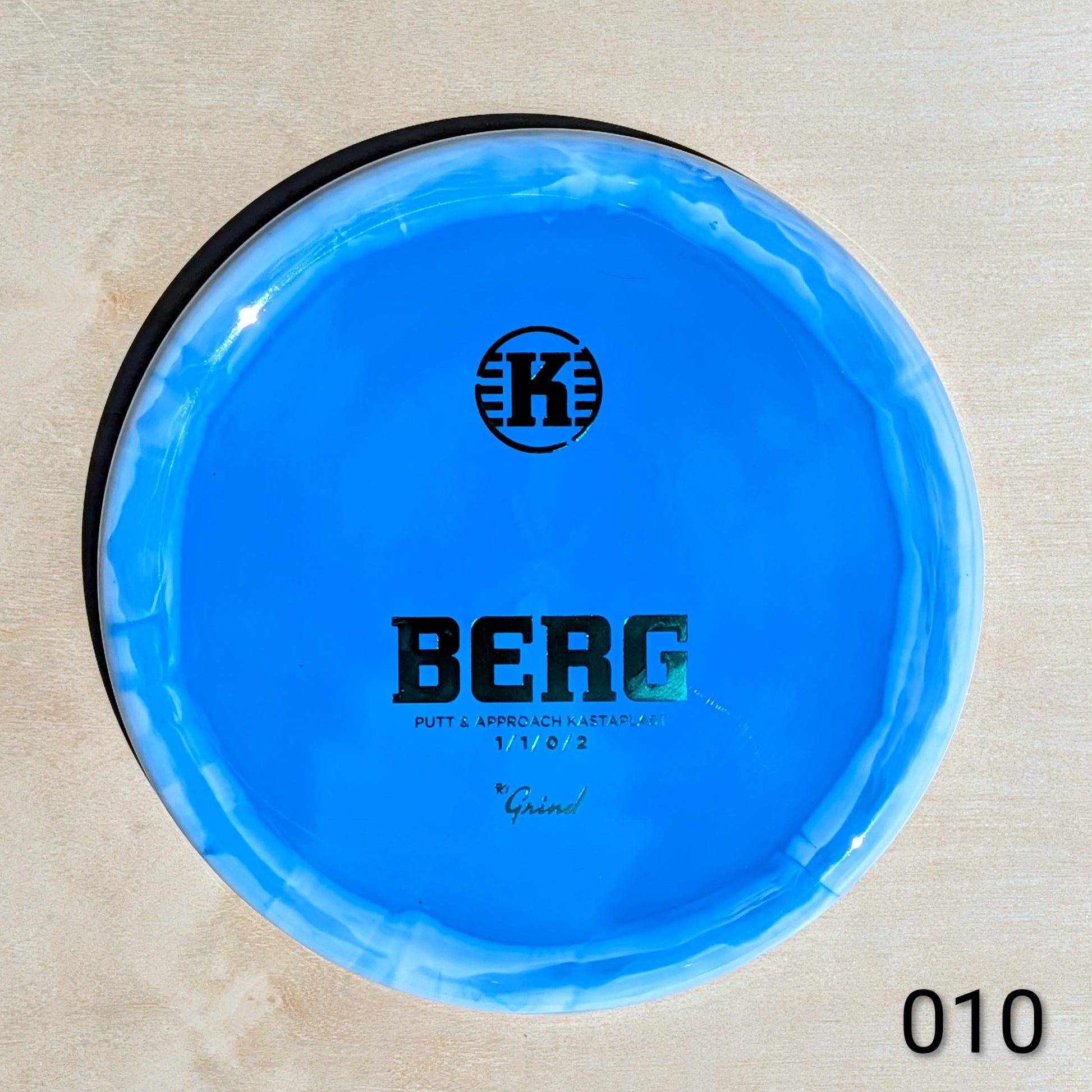 Blue disc with 'BERG' branding on a beige background