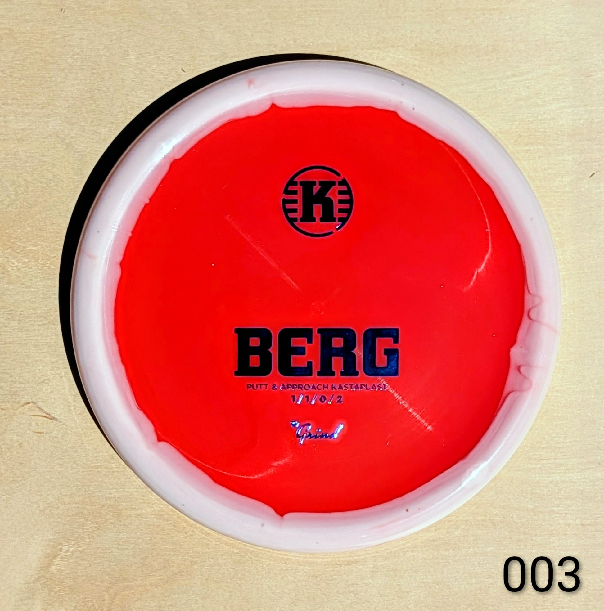 Red disc with 'K' logo and 'BERG' text on a beige background