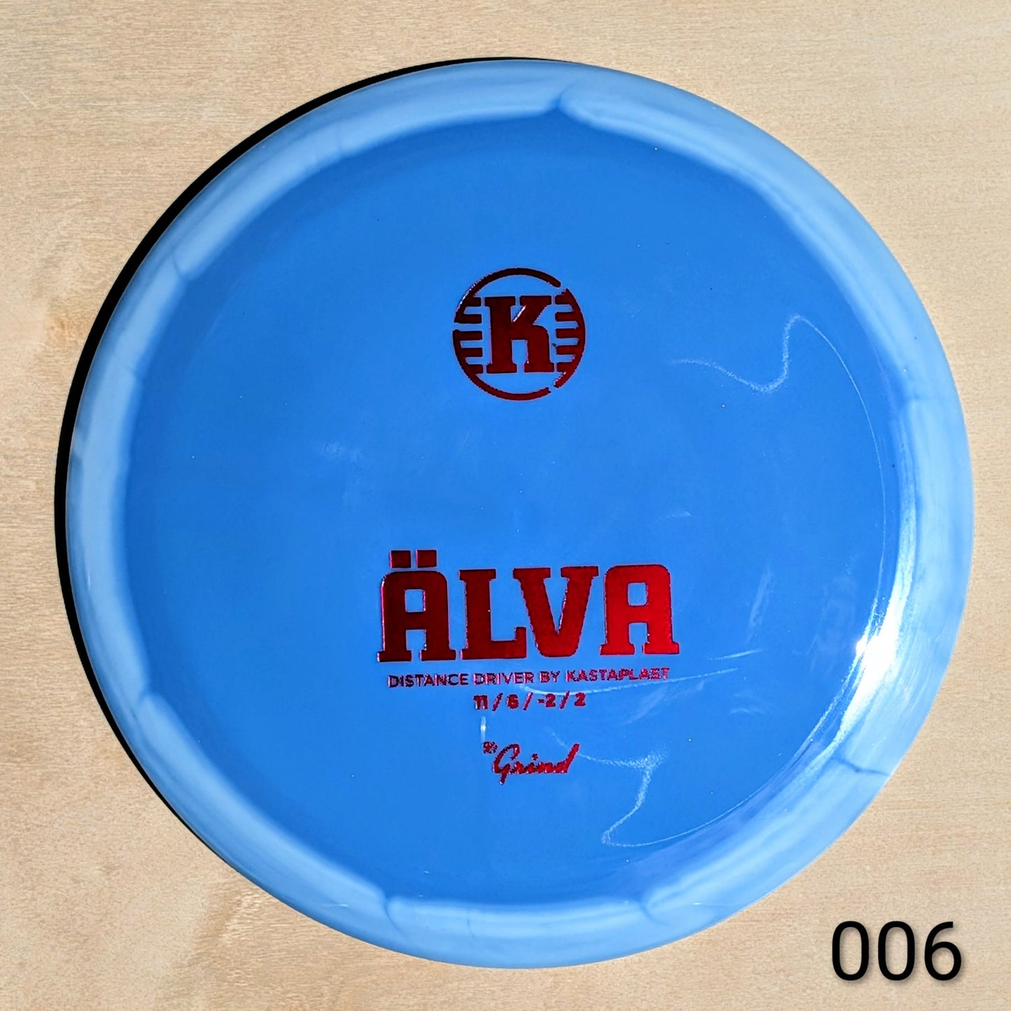 Blue disc golf disc with red text on a beige background