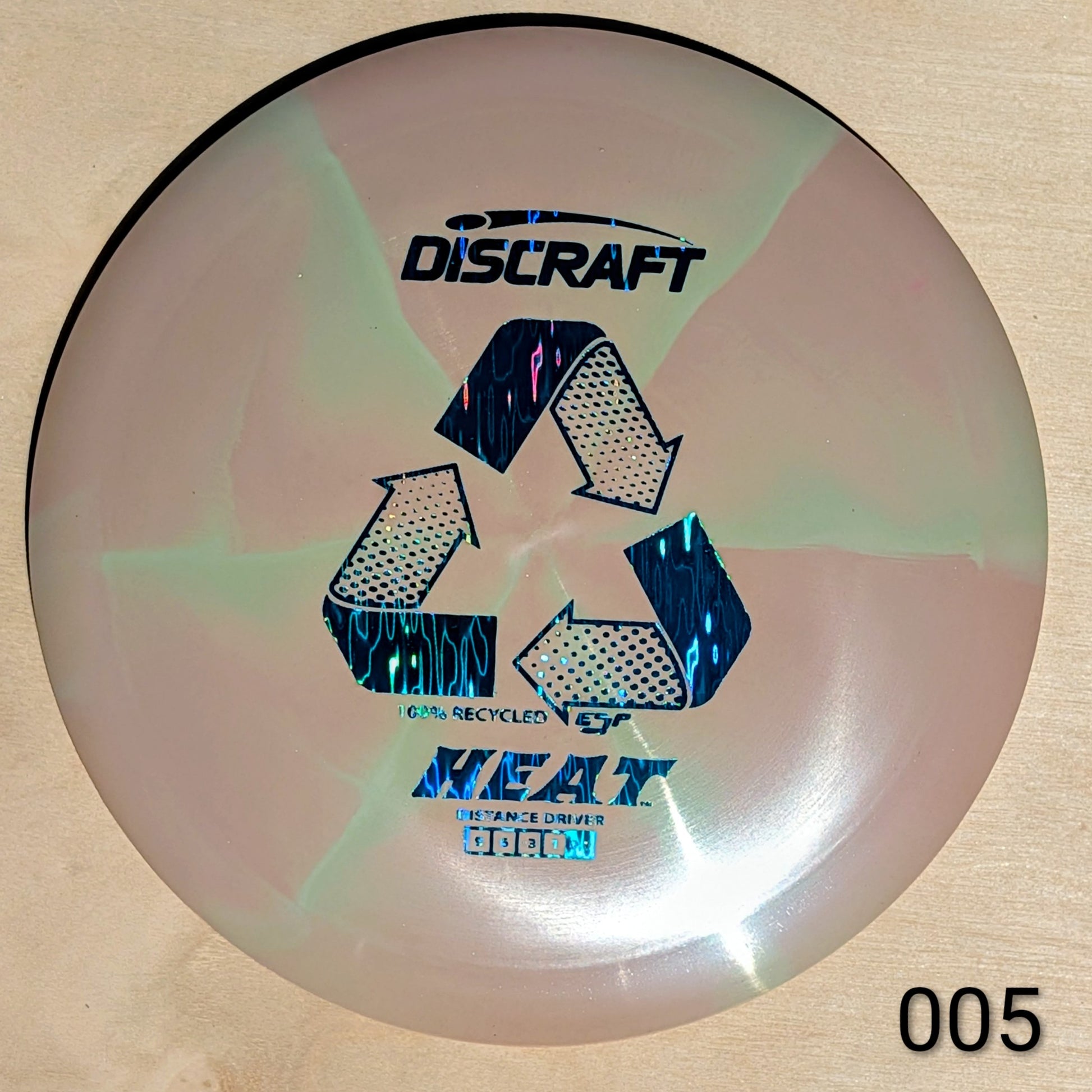 Discraft disc golf disc with recycling symbol and text on a beige background