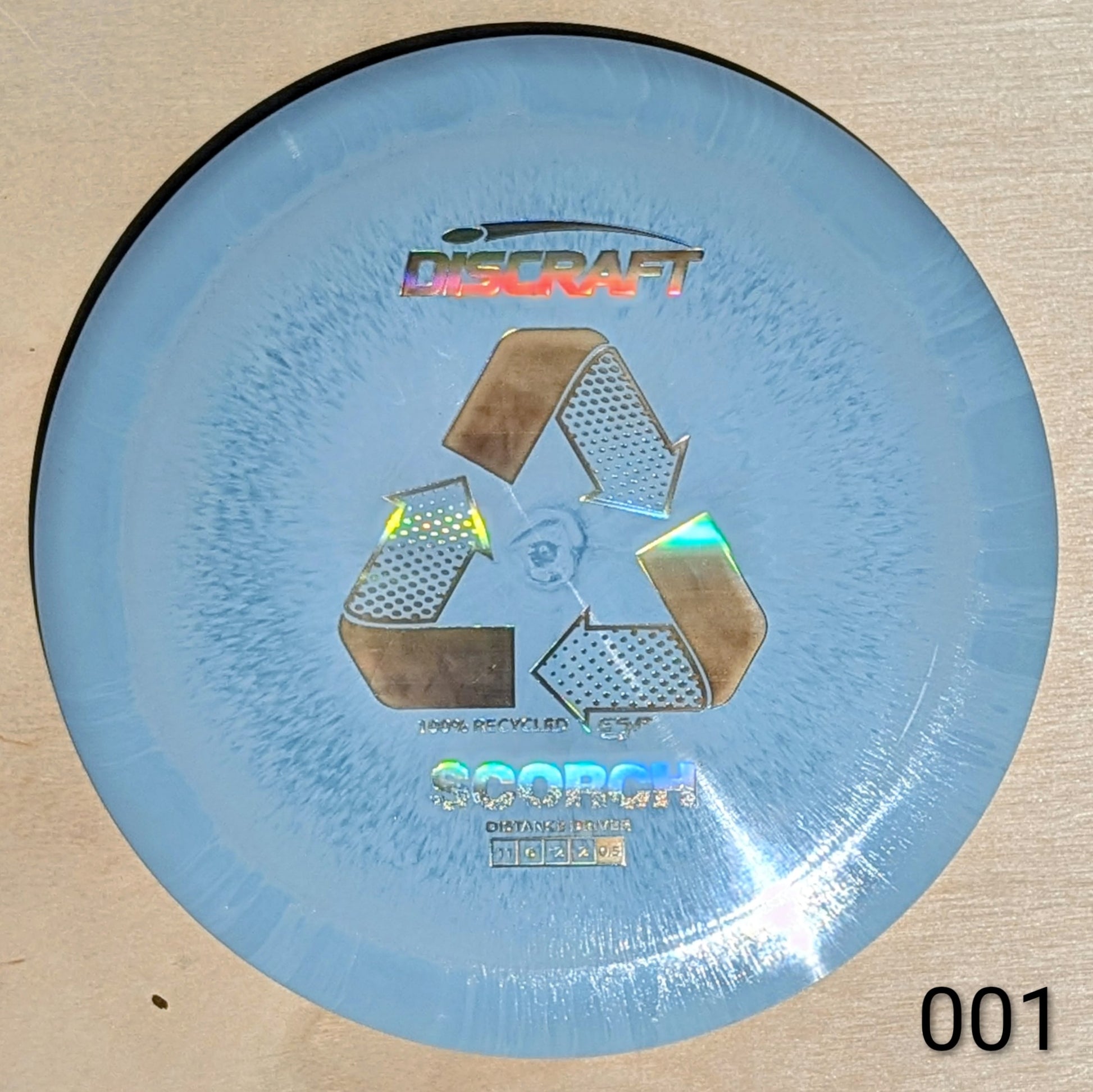 Blue disc with Discraft logo and recycling symbol on a beige background