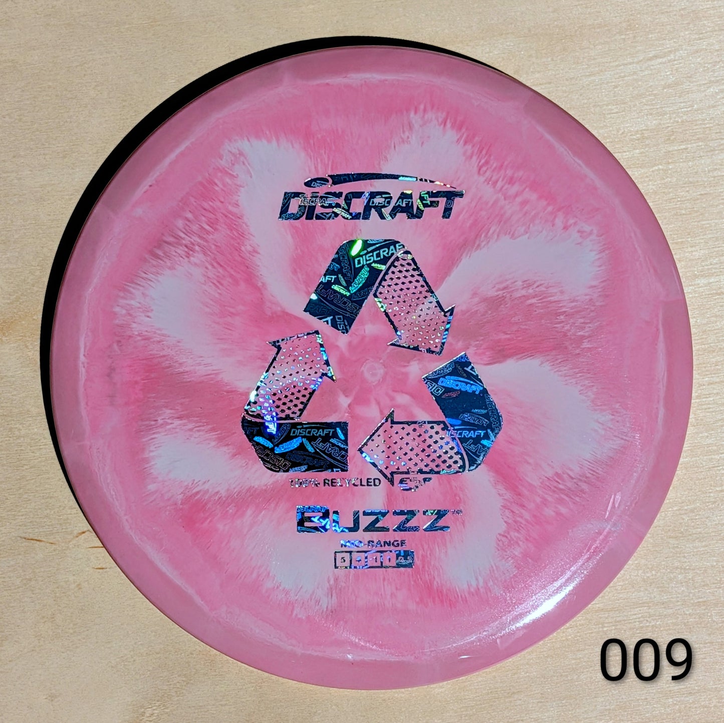 Pink disc with Discraft branding on a wooden surface