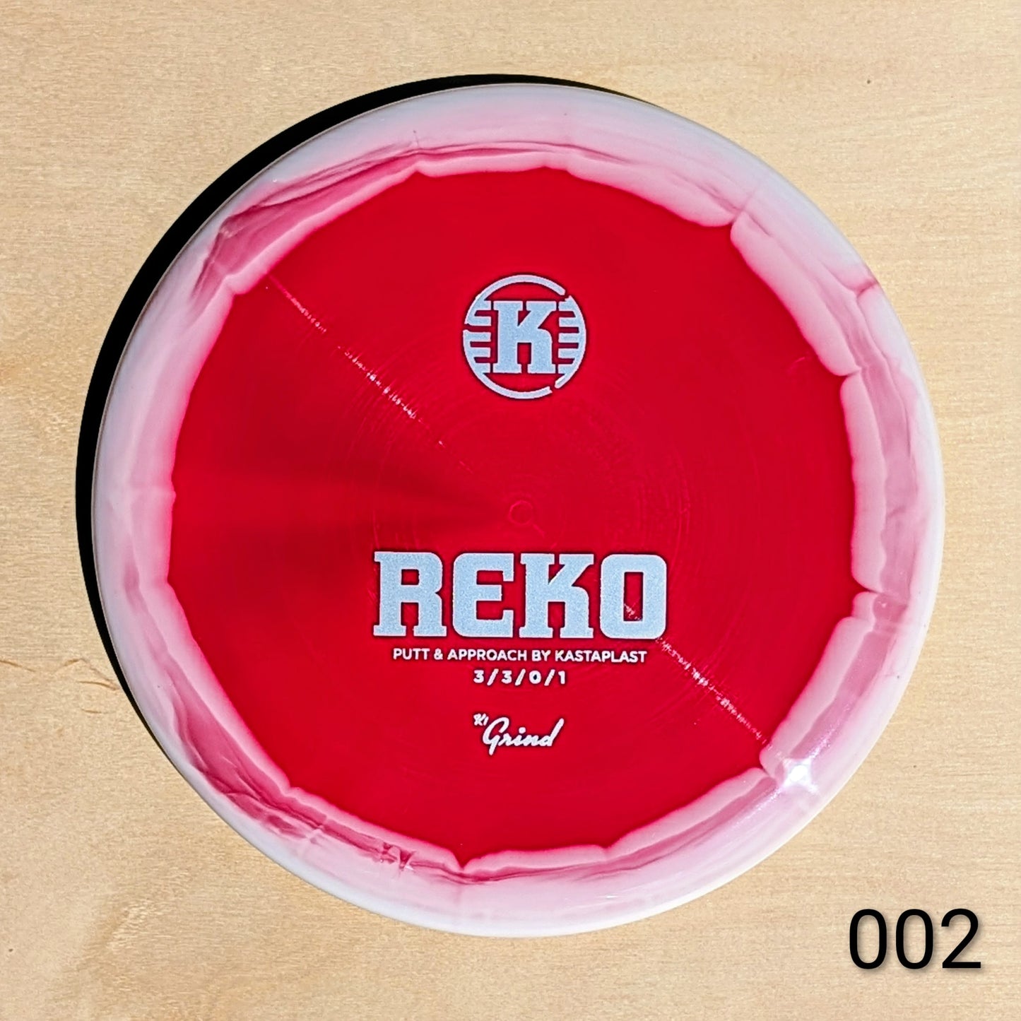 Red disc with 'REKO' branding on a beige background