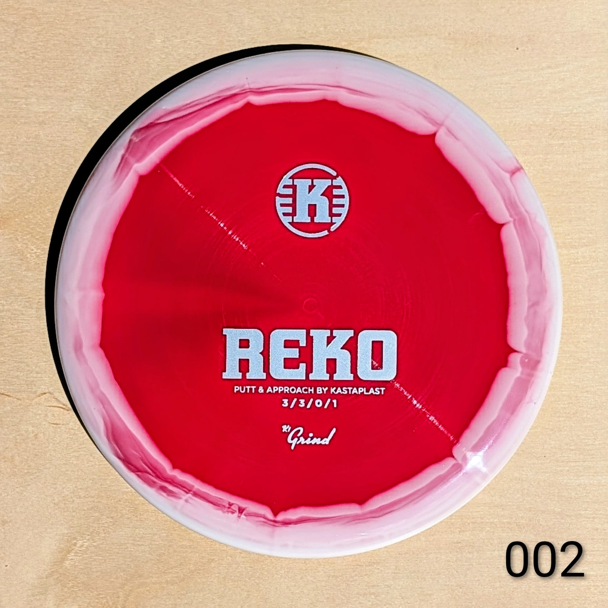 Red disc with 'REKO' branding on a beige background