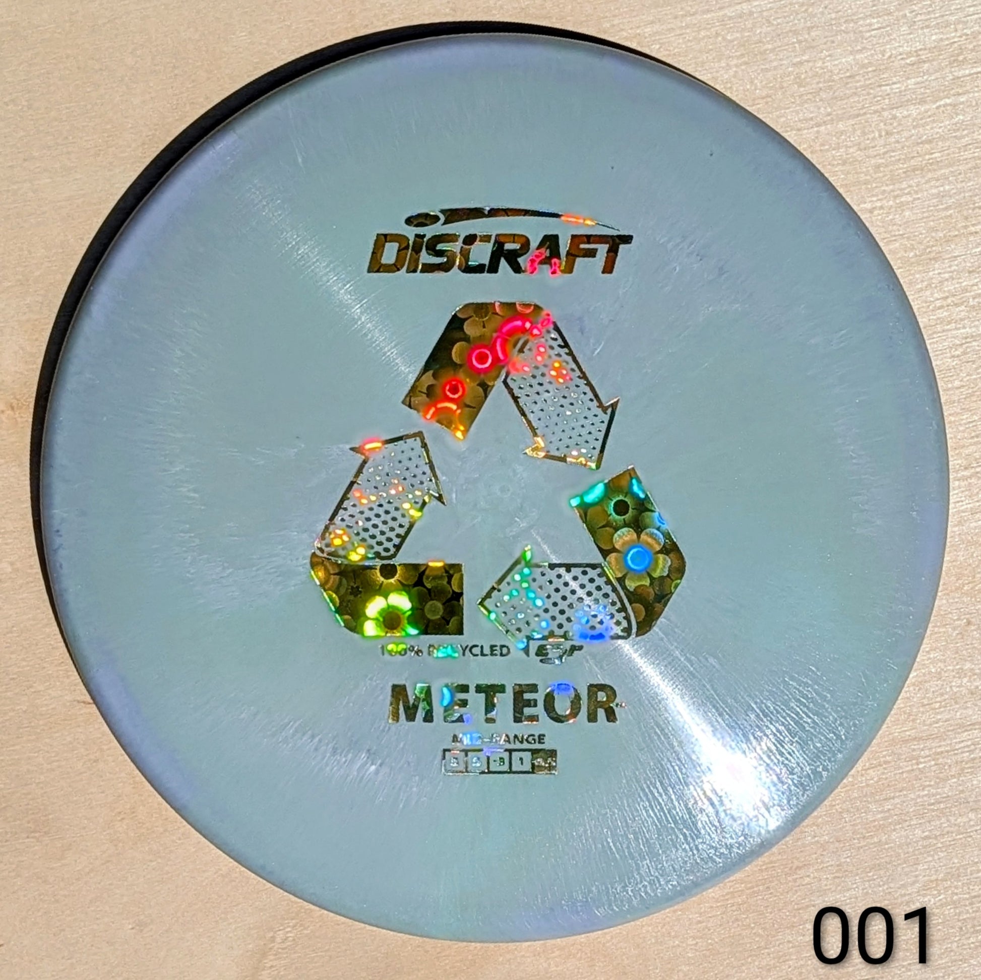 Discraft Meteor disc golf disc on a beige background