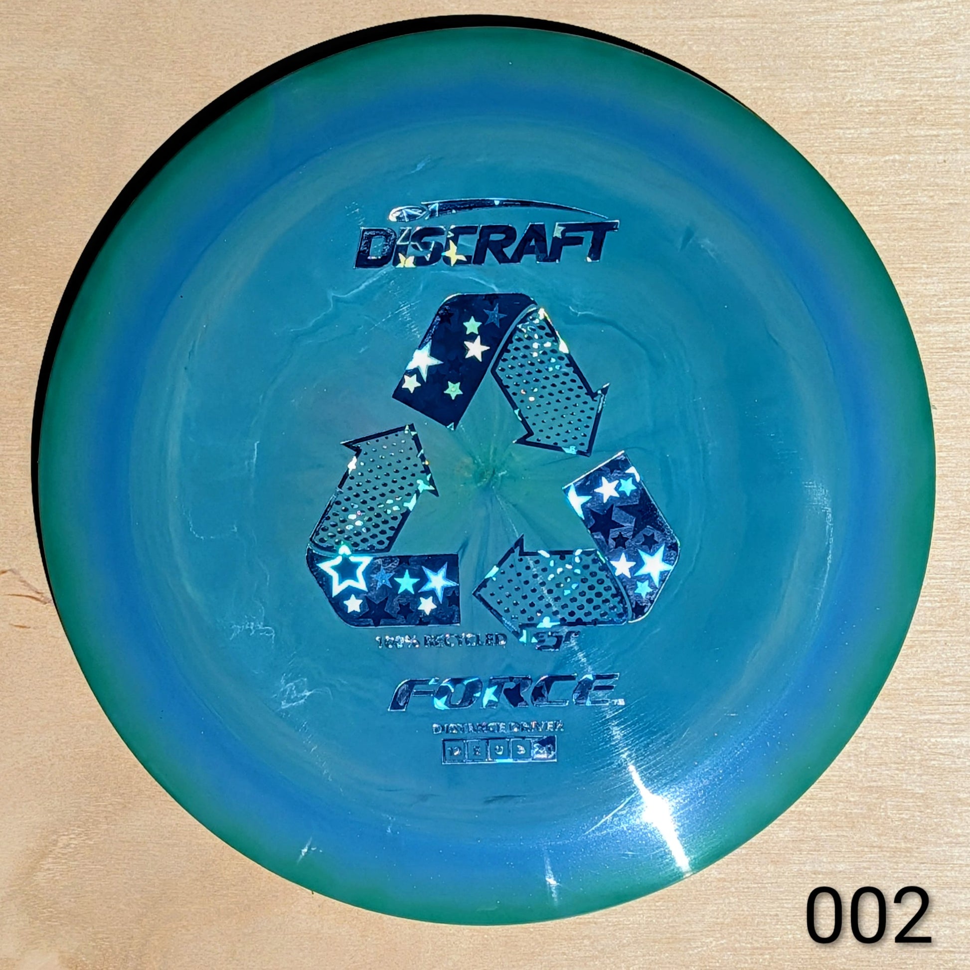 Blue Discraft disc golf disc on a beige background