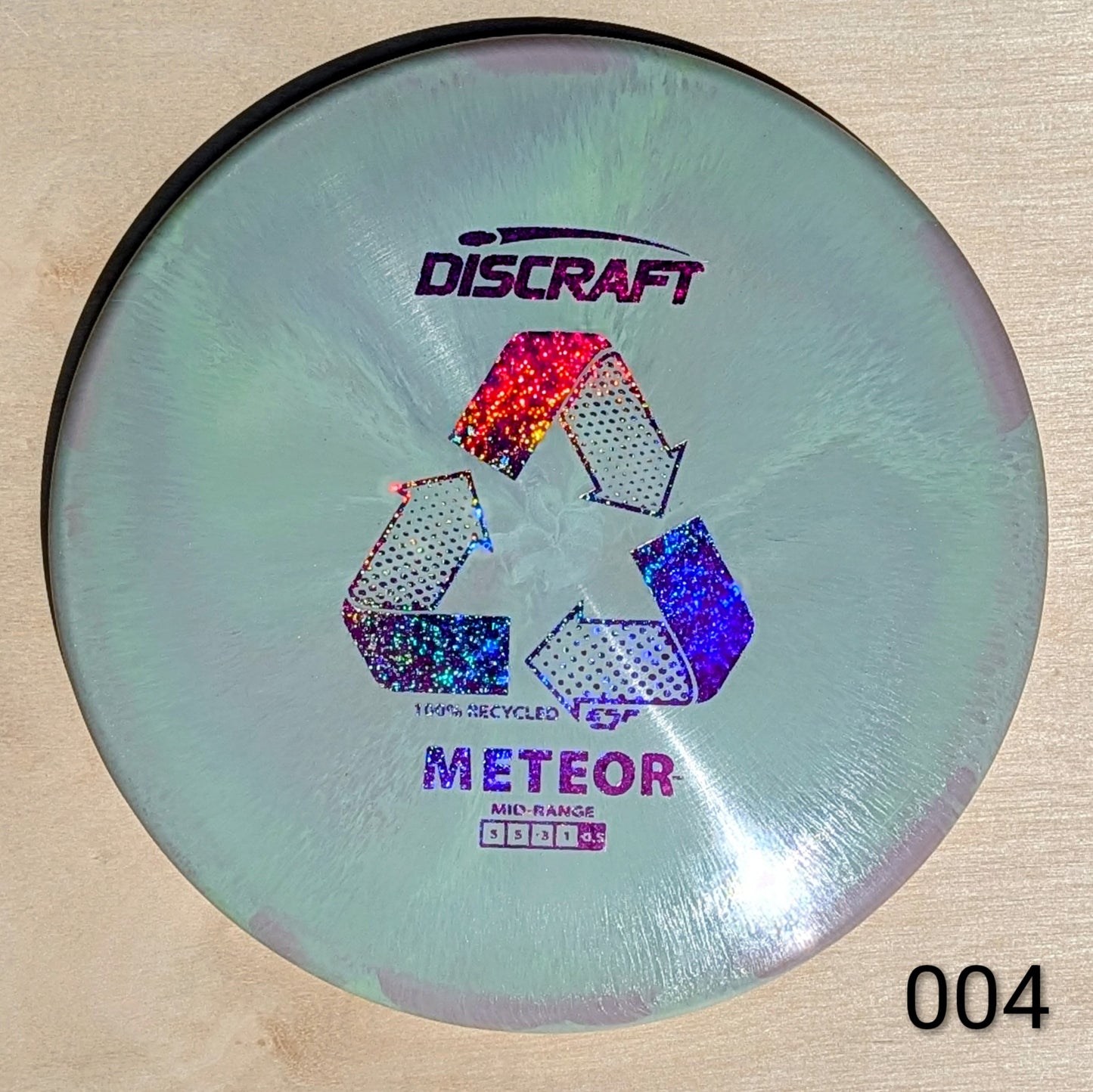 Discraft Meteor disc golf disc on a wooden surface