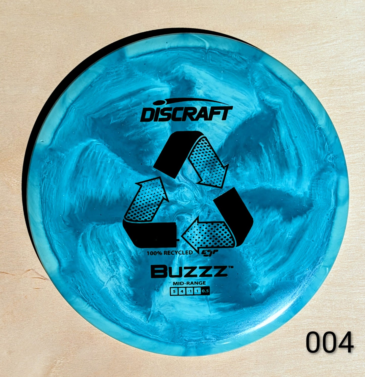Blue Discraft Buzzz disc golf disc on a beige background