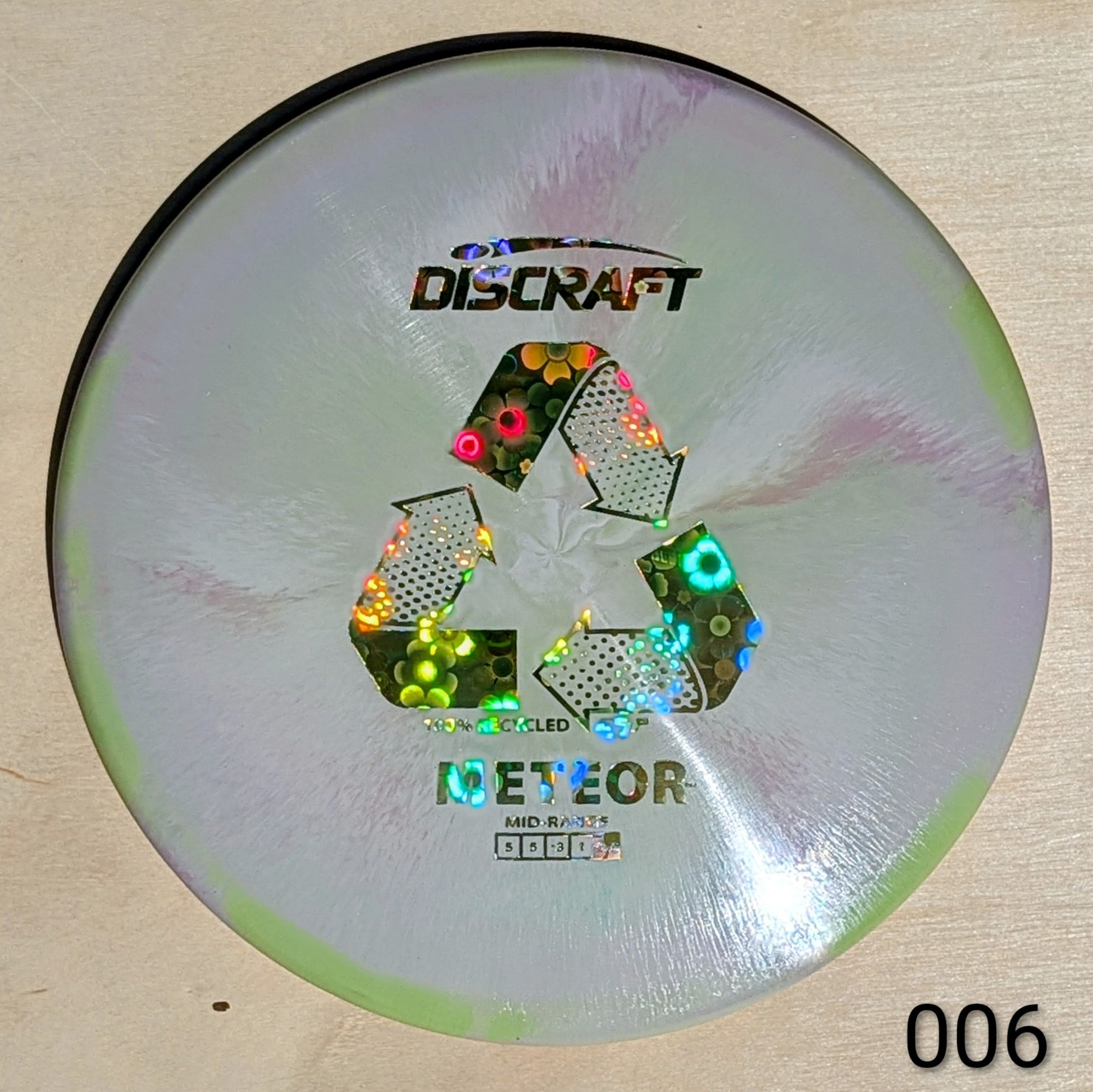 Discraft Meteor disc golf disc on a wooden surface