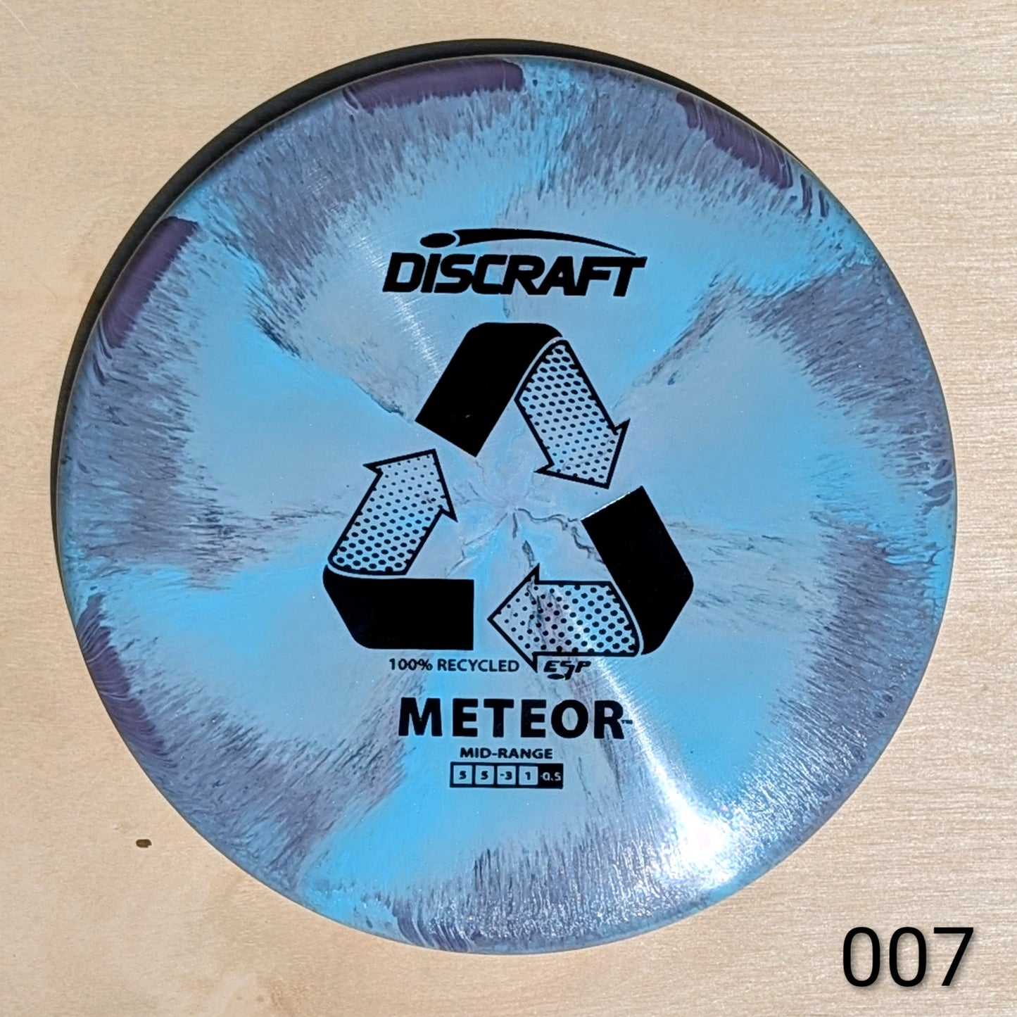 Discraft Meteor disc golf disc on a beige background
