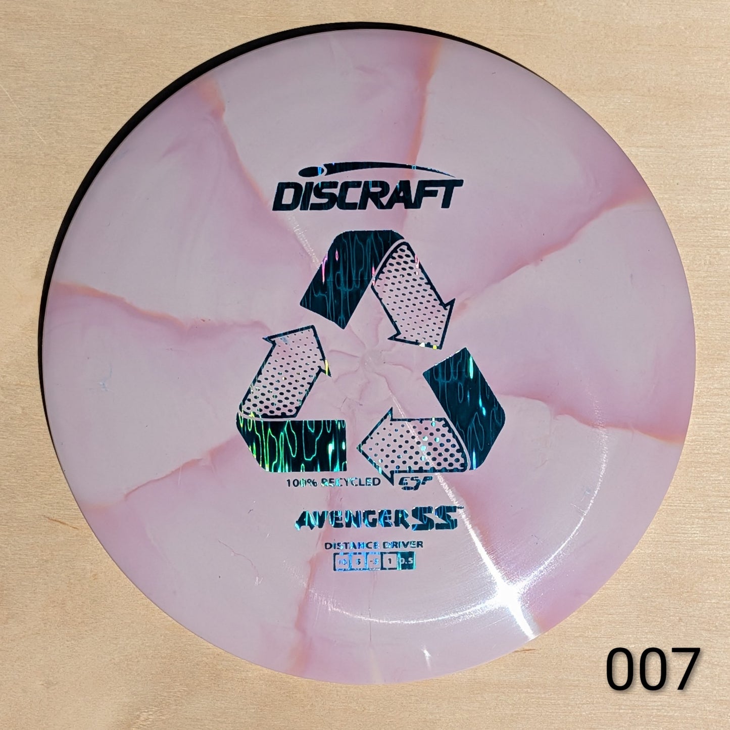 Discraft disc golf disc with pink and white design on a beige background