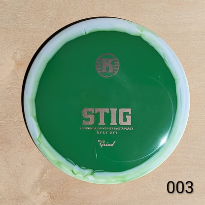 Green disc golf driver with 'K' logo on a beige background