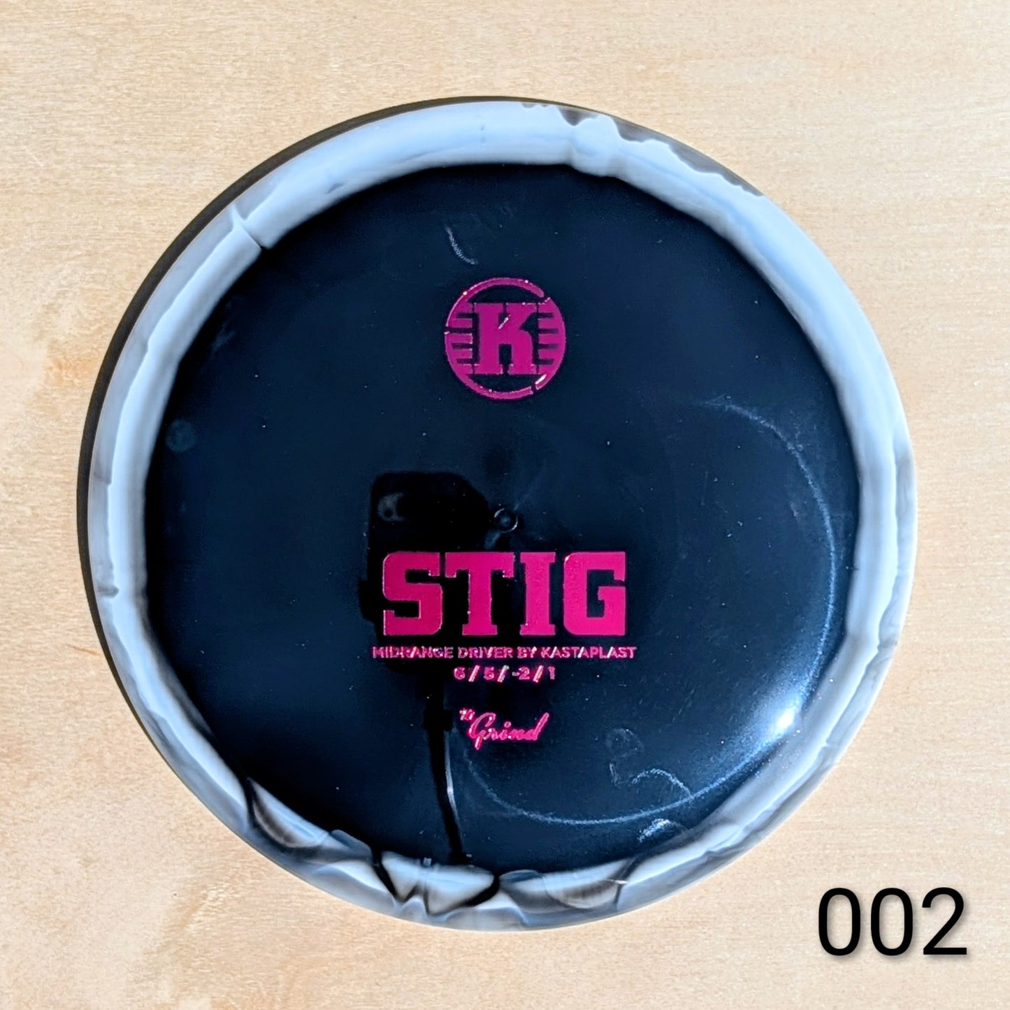 Top view of a dark blue container with pink text and branding on a beige background