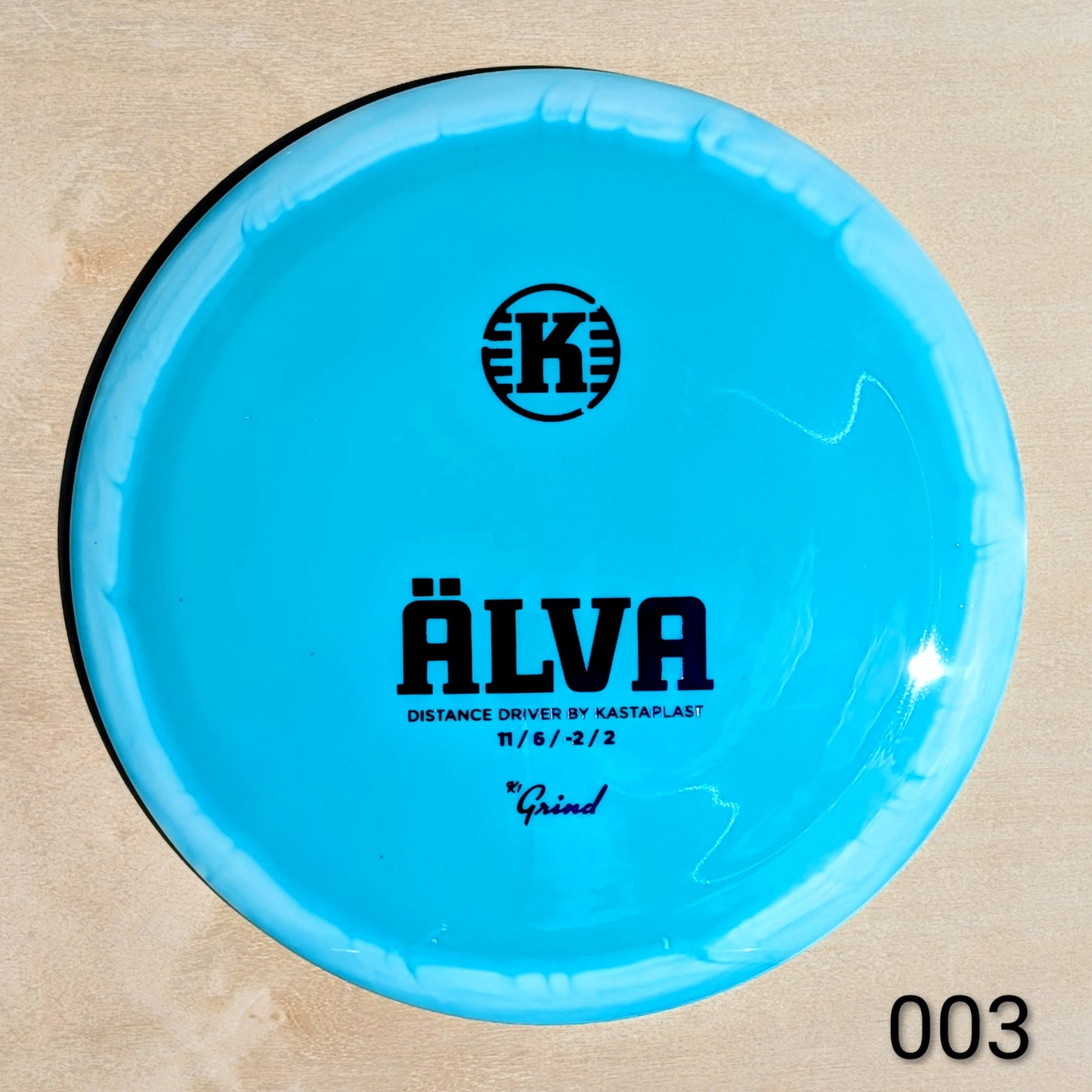 Blue disc golf disc with 'Kastaplast' branding on a beige background