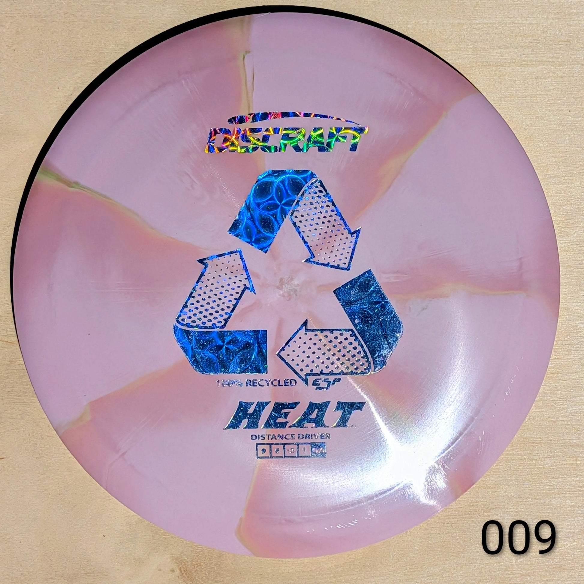 Pink disc with blue recycling symbols and text on a beige background