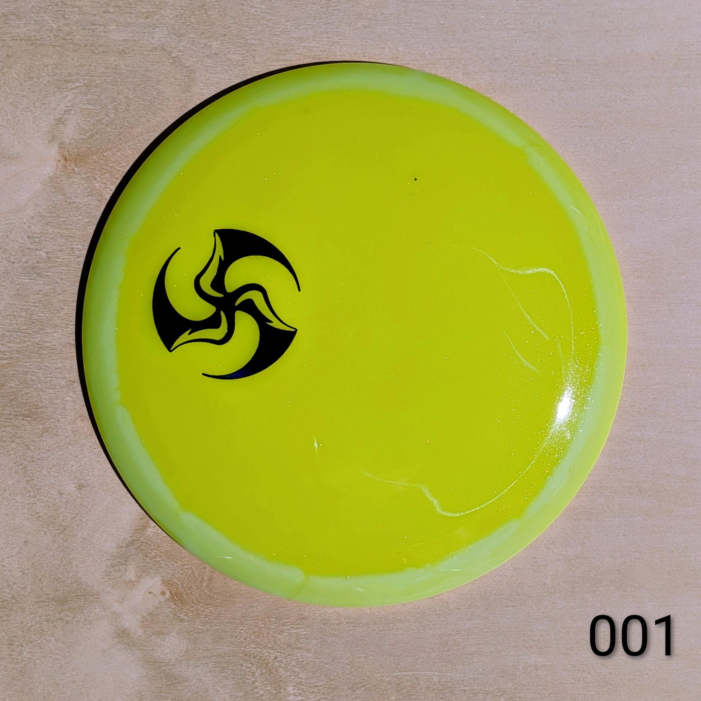Yellow disc with a black logo on a beige background
