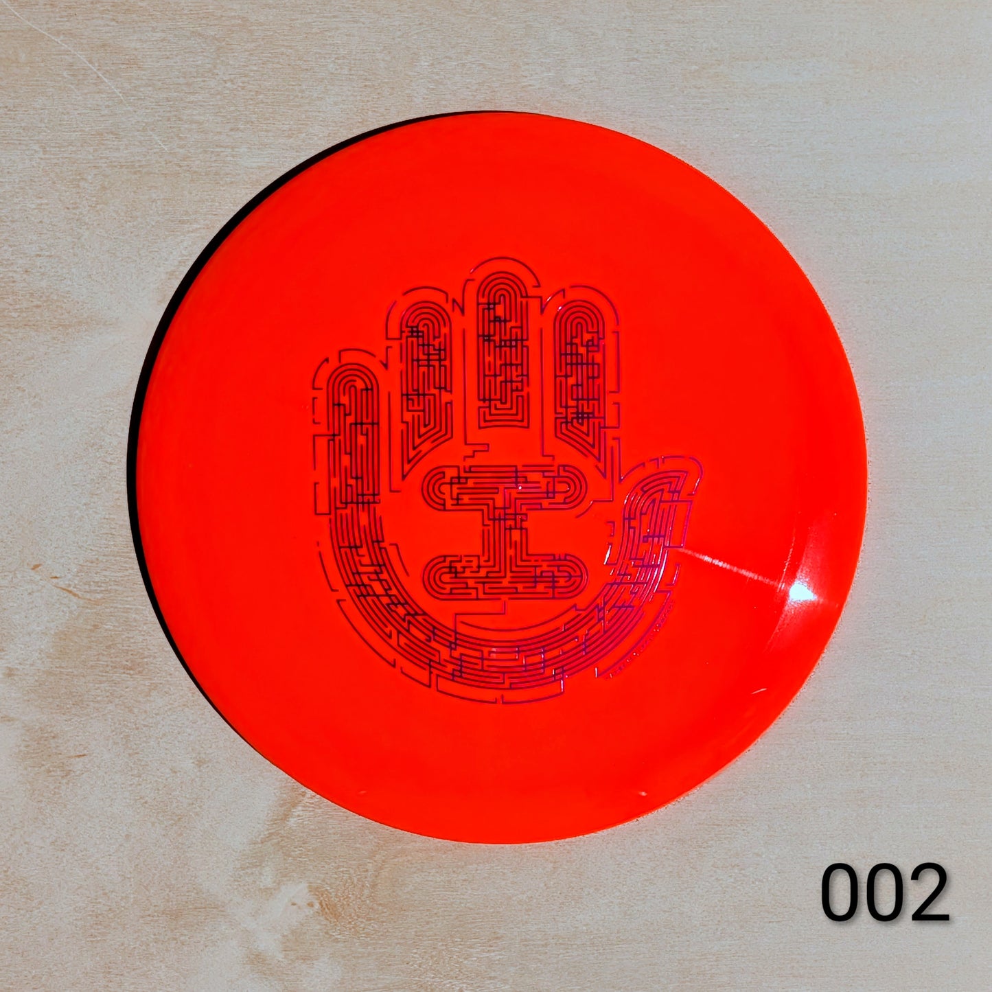 Red disc with black text and design on a beige background