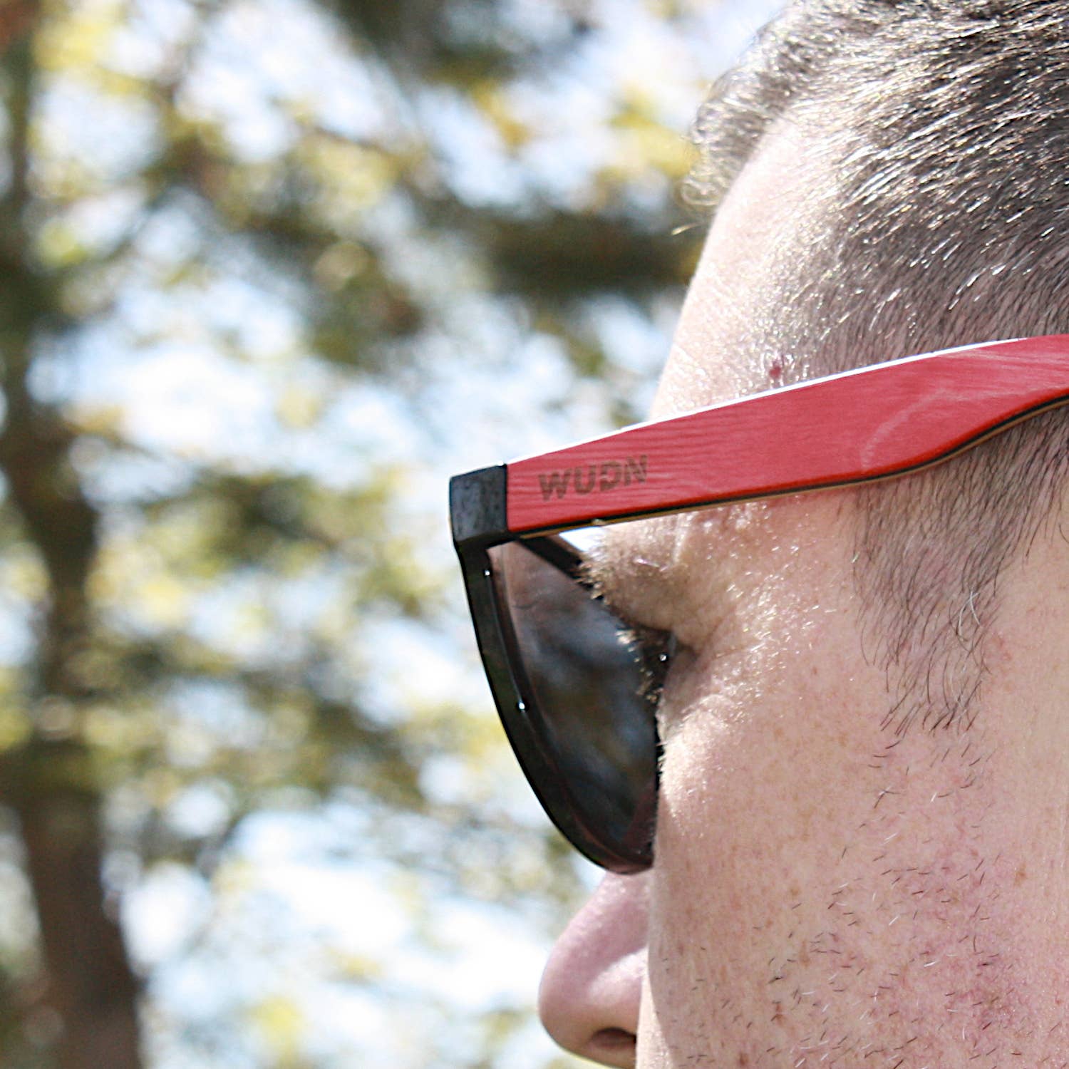 bluntslide red sunglasses with 'WUDN' branding outdoors