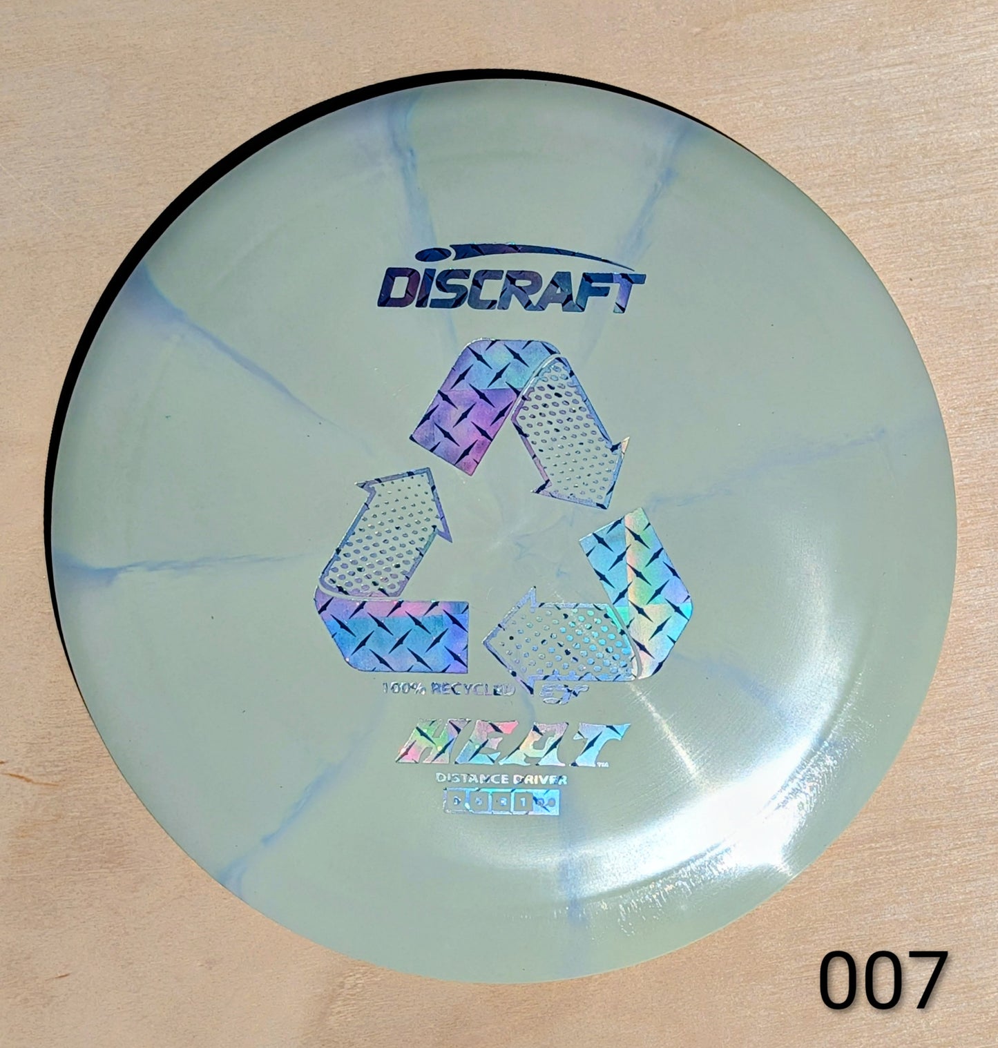 Discraft disc golf disc with recycling symbol on a wooden surface