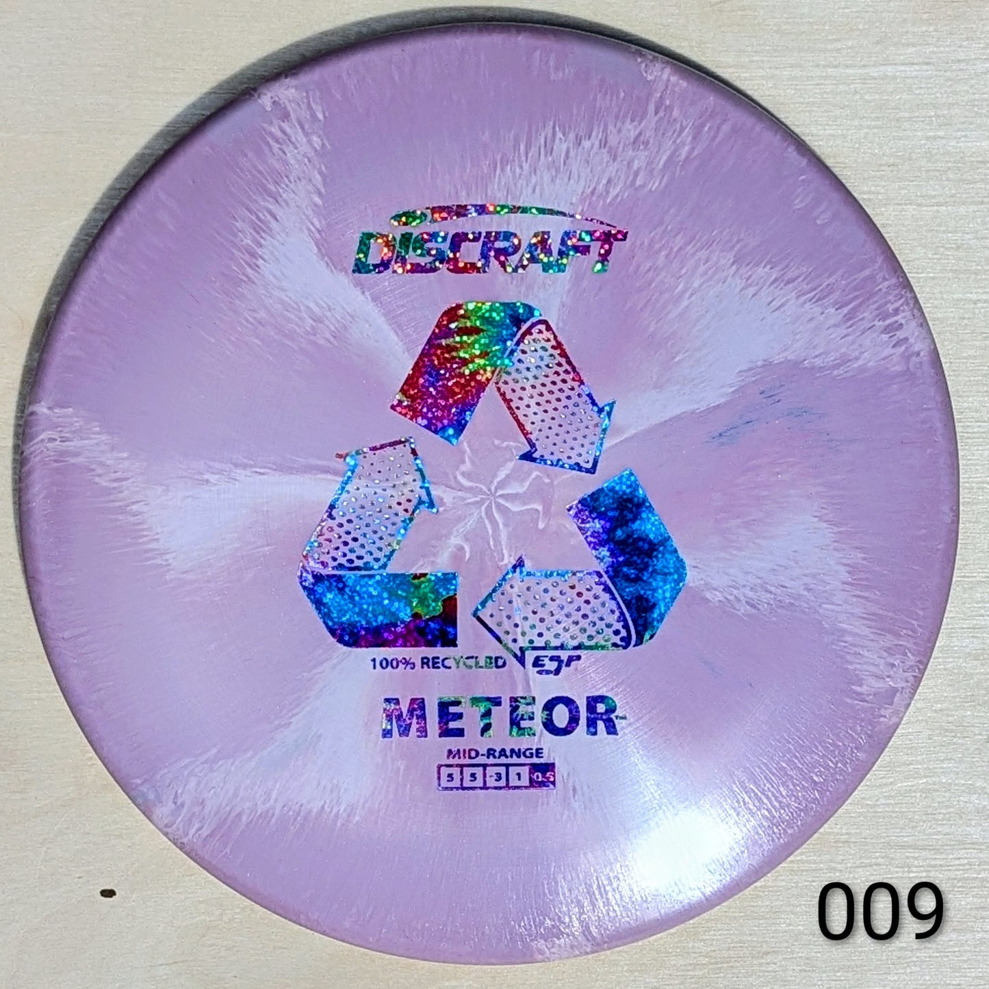 Discraft Meteor disc golf disc with recycling symbol on a light background