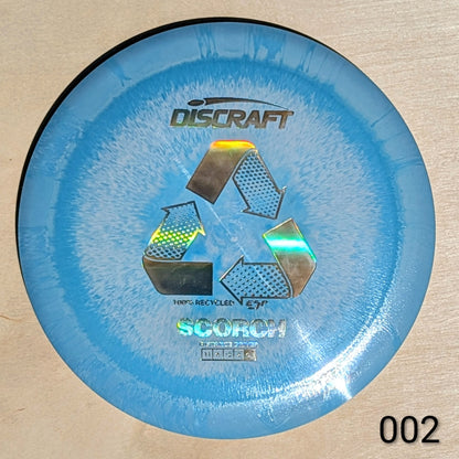 Blue Discraft Scorch disc golf disc on a beige background