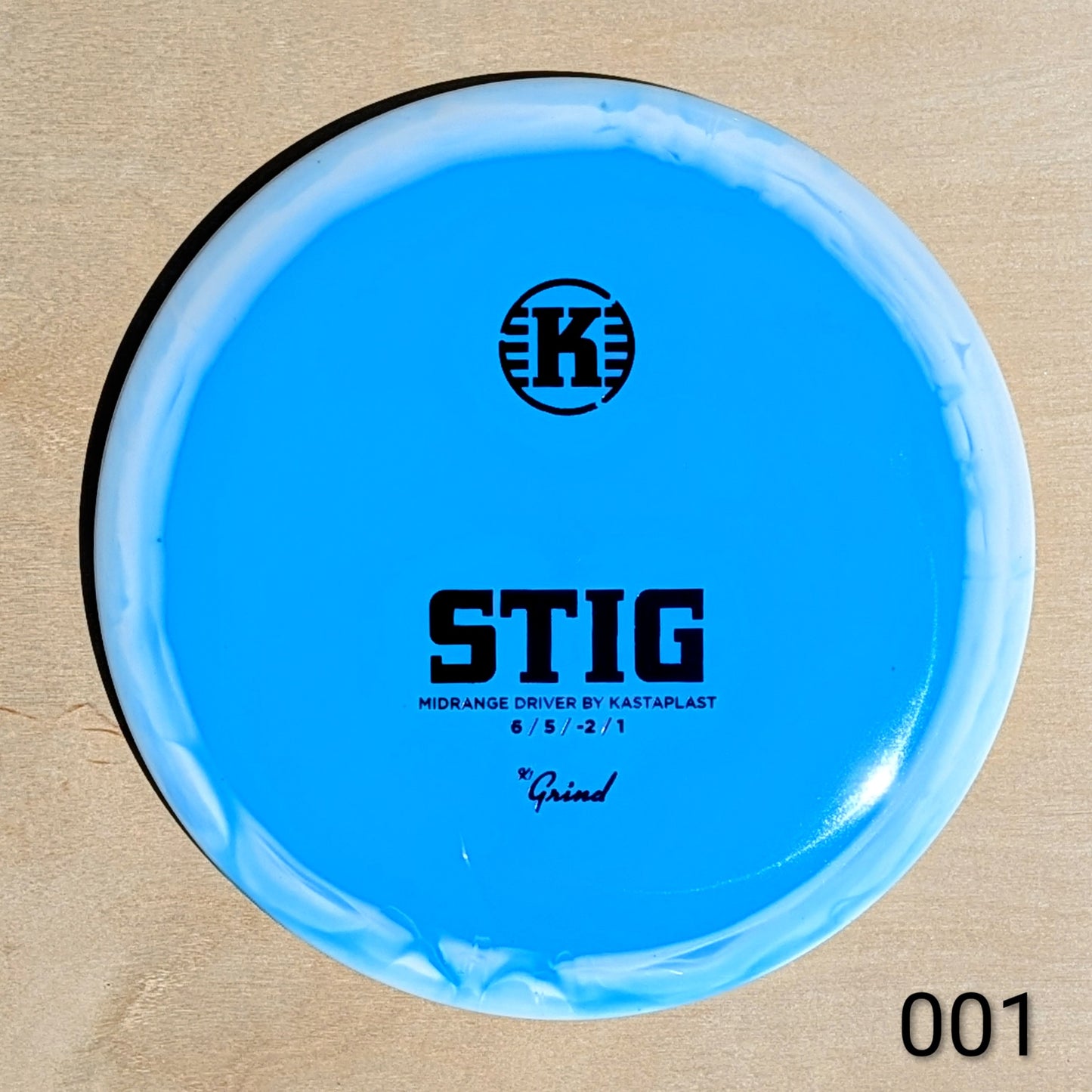 Blue disc golf disc with 'K' logo and text on a beige background